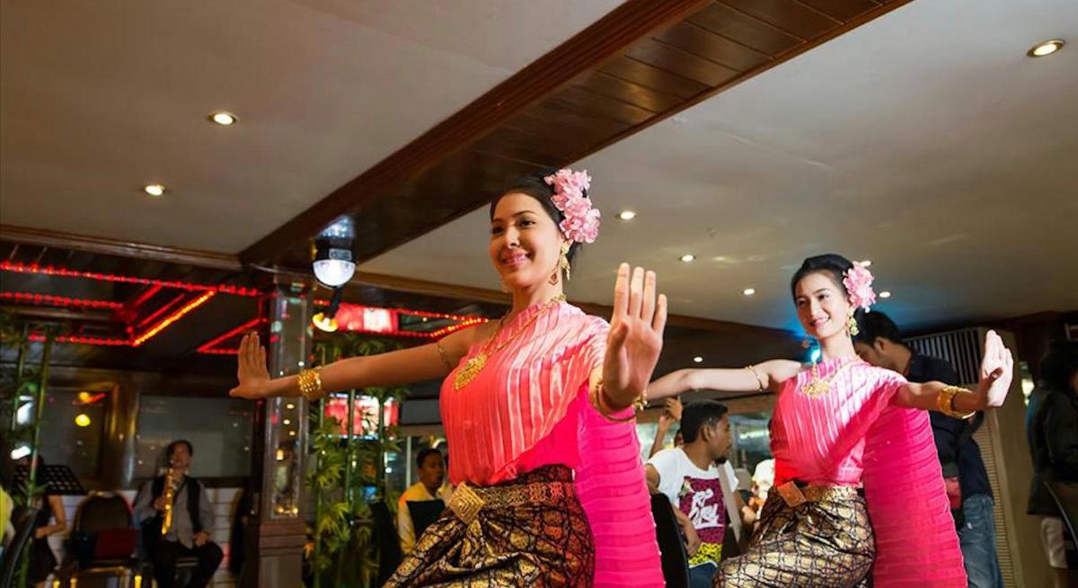 two women in pink clothes dancing in a bar
