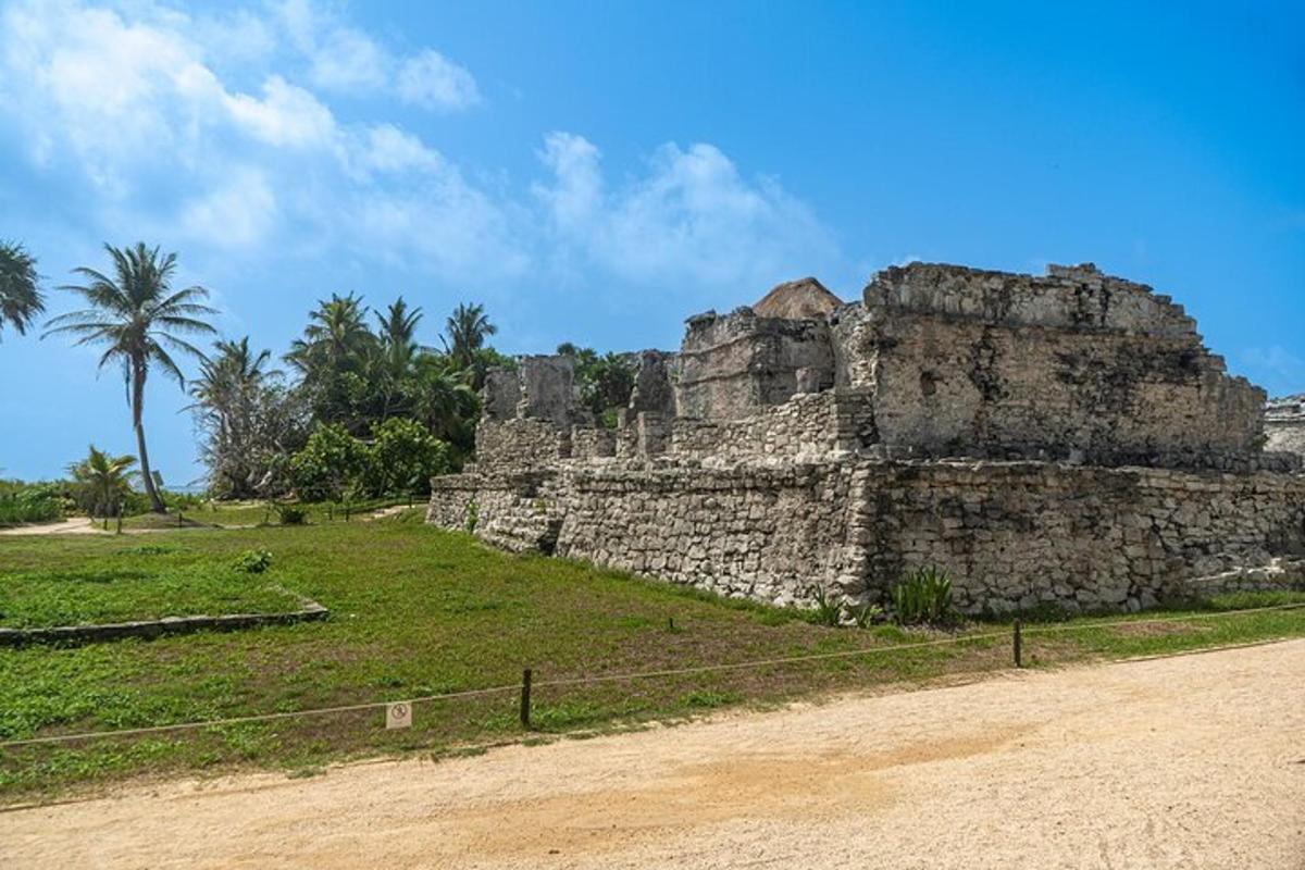 Un antiguo edificio de piedra con palmeras al fondo.