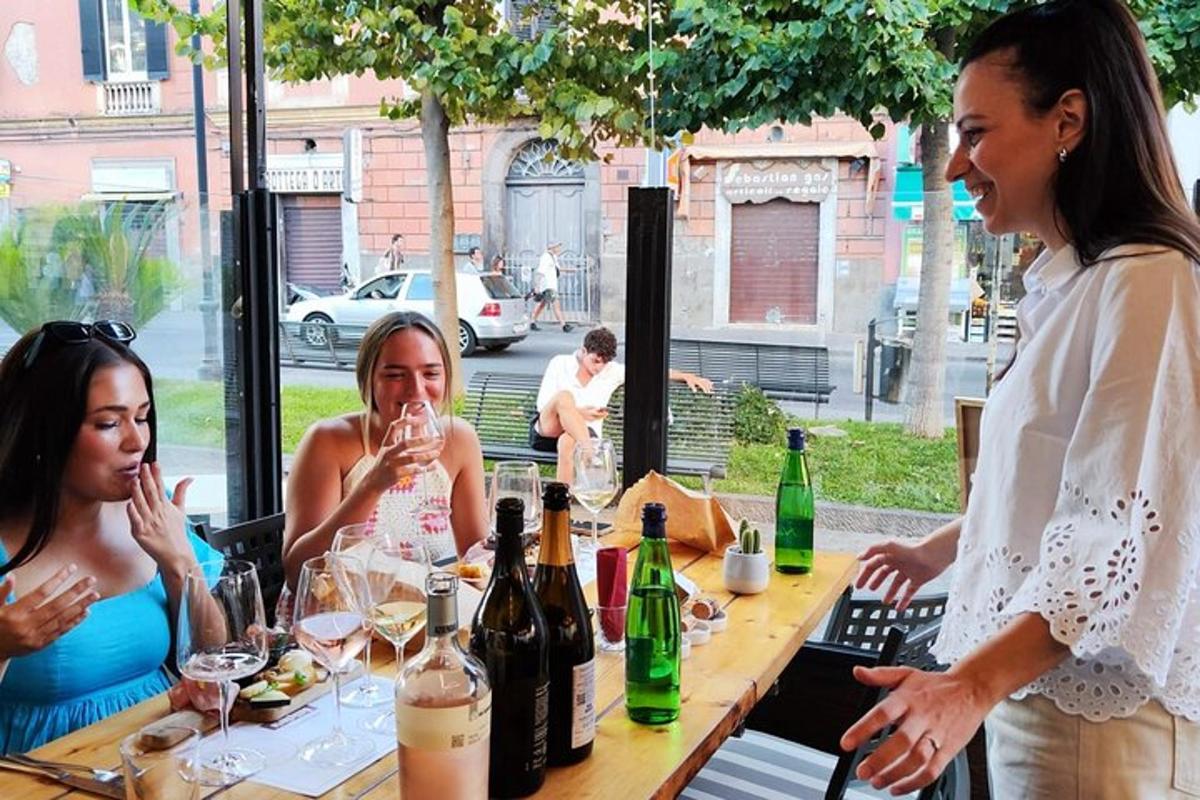 um grupo de mulheres sentadas à mesa com garrafas de vinho