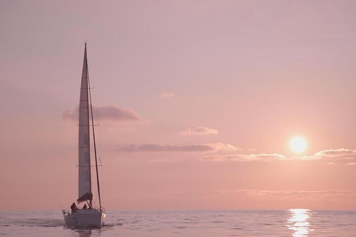 o barcă cu pânze în ocean la apus