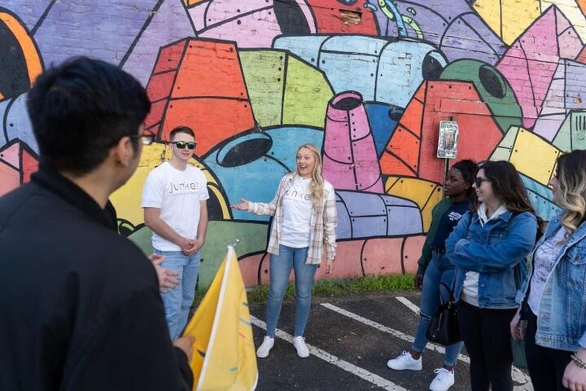 sekumpulan orang berdiri di hadapan mural