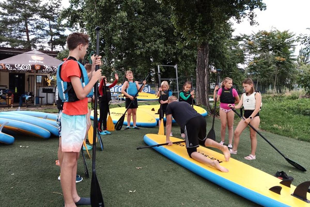 un gruppo di giovani in piedi su tavole da paddle