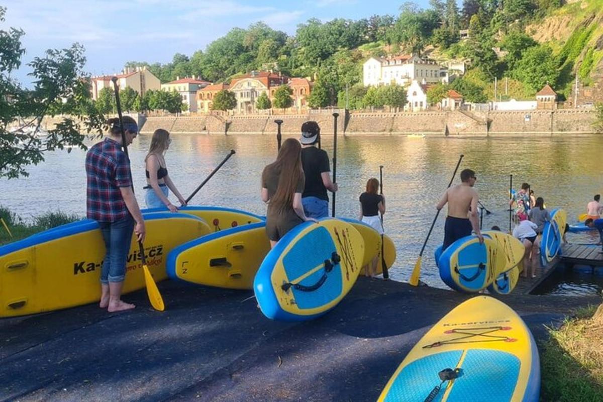 Un grupo de personas de pie en el agua con kayaks.
