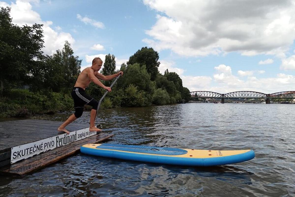 een man springt van een surfplank in het water