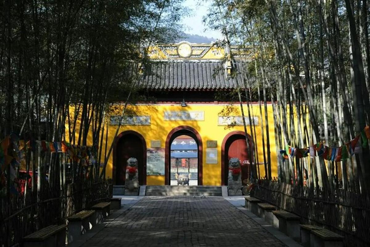 a yellow building with a gate with benches in front
