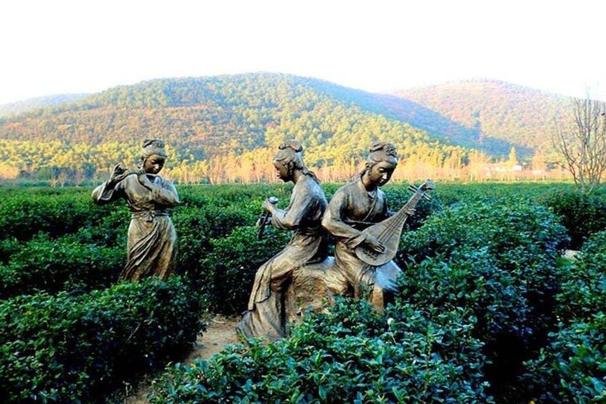 a statue of three women sitting in a field