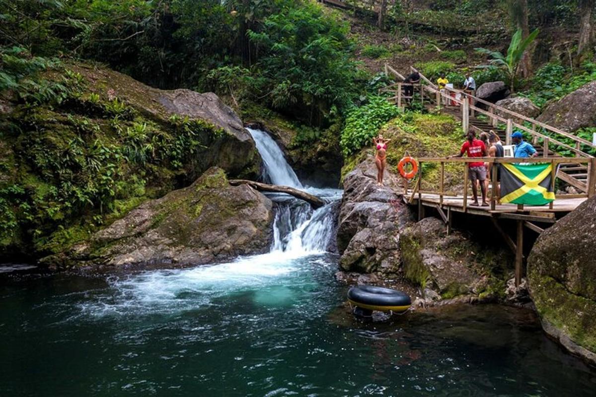 un gruppo di persone in piedi su un ponte sopra una cascata
