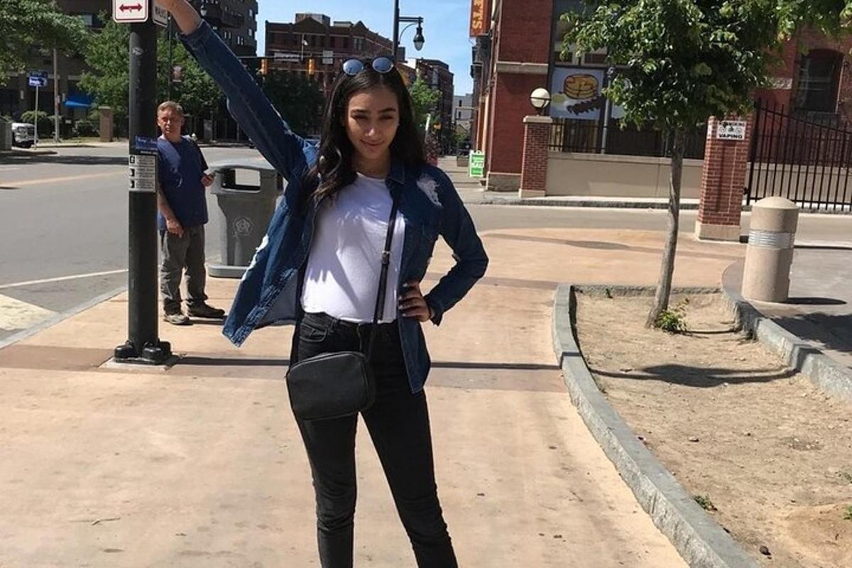 žena stojící na ulici s rukou ve vzduchu