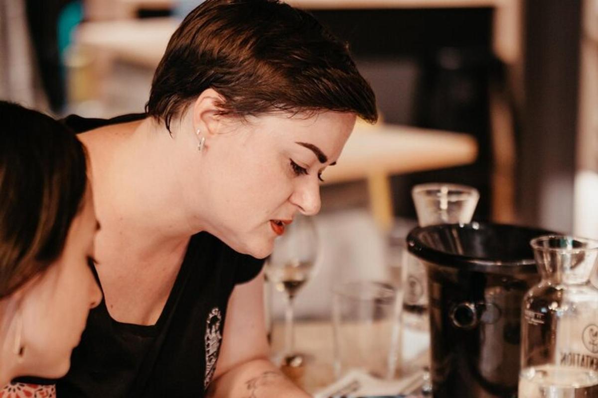 zwei Frauen sitzen mit Weingläsern an einem Tisch