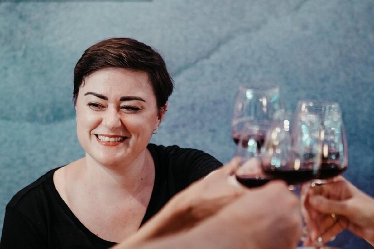 una dona que sosté dues copes de vi negre