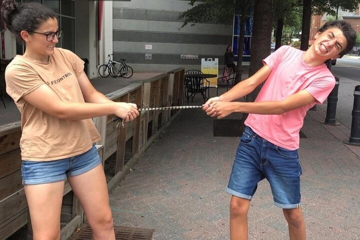 two young people playing with a rope