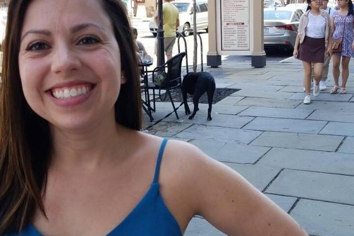 a woman in a blue tank top with a dog