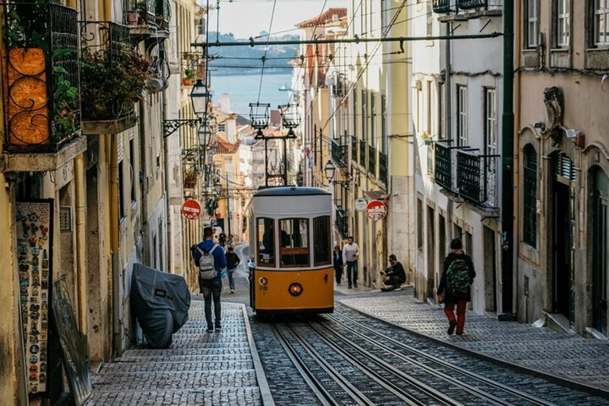 a yellow tram on a street with buildings