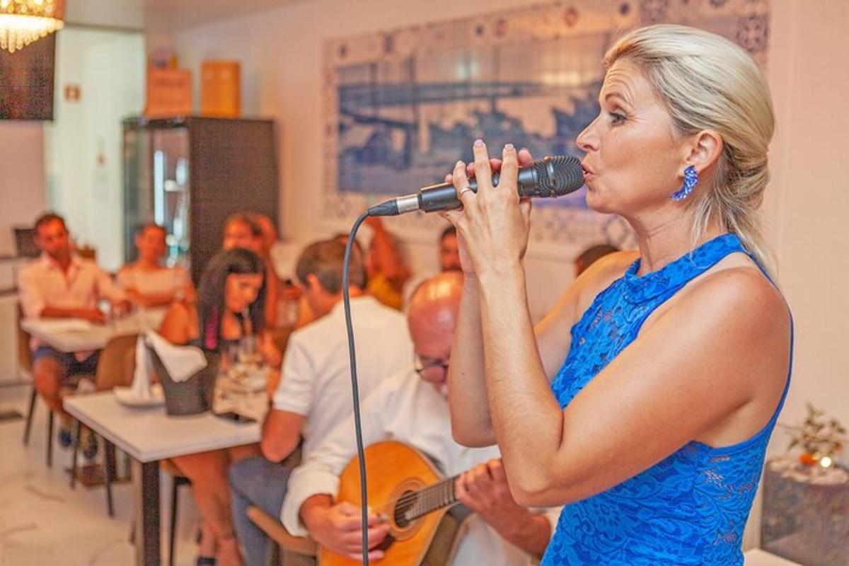 Μια γυναίκα τραγουδάει σε ένα μικρόφωνο με μια ομάδα ανθρώπων