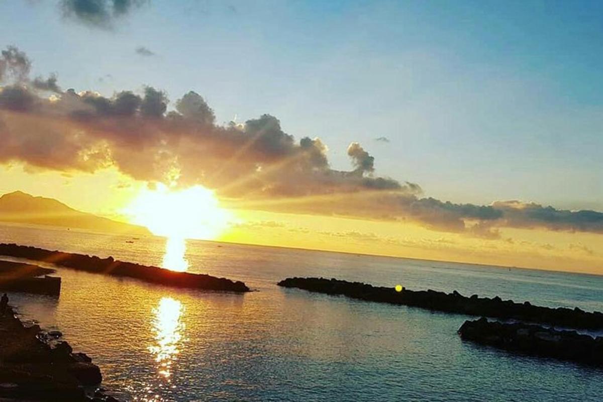 um pôr do sol sobre o oceano com o sol no céu