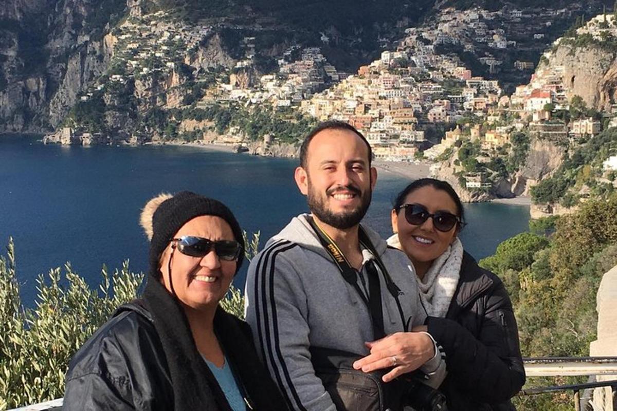três pessoas posando para uma foto na encosta de uma montanha