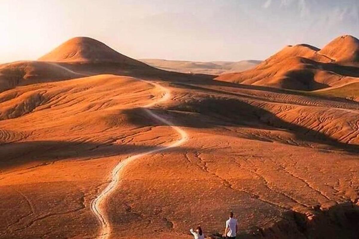 two people standing on top of a desert