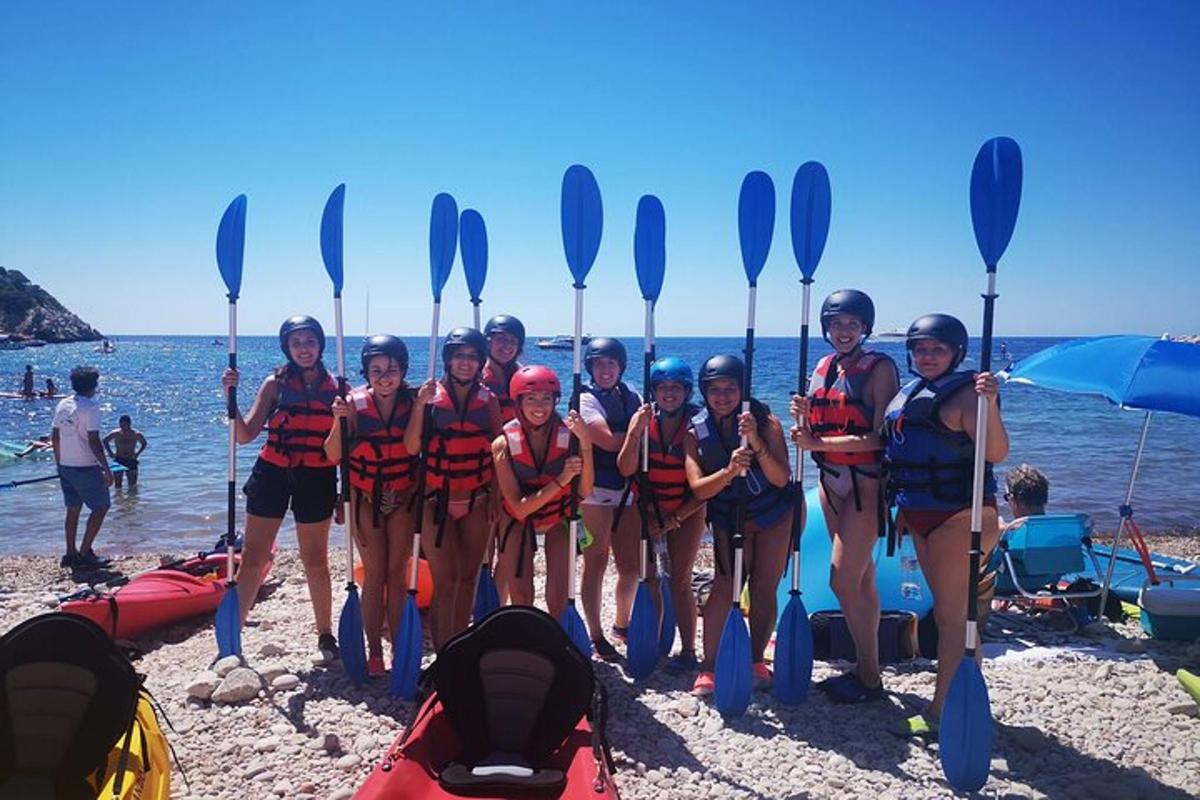 un gruppo di donne in piedi sulla spiaggia con le pagaie