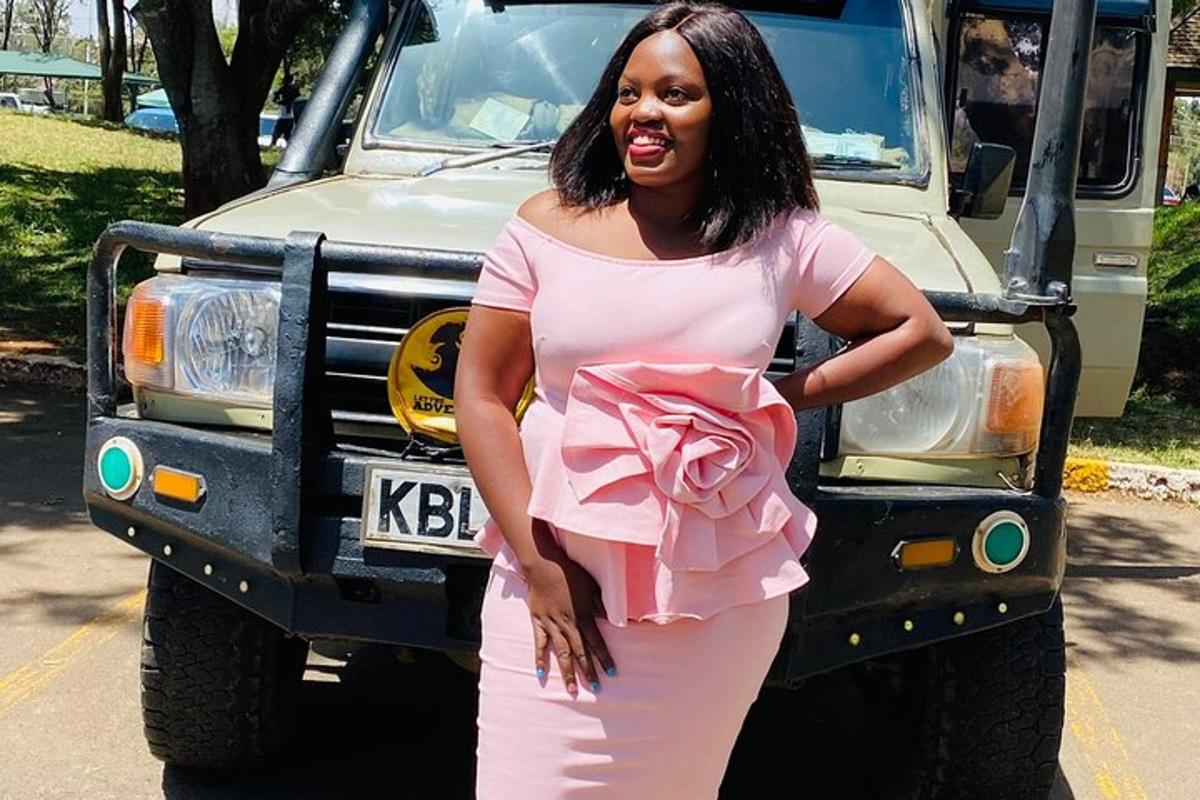 uma mulher de vestido rosa parada na frente de um caminhão