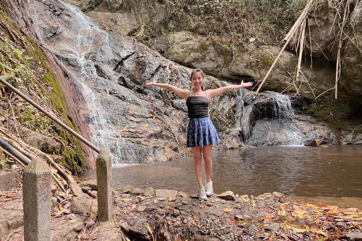 una donna in piedi nell'acqua vicino a una cascata