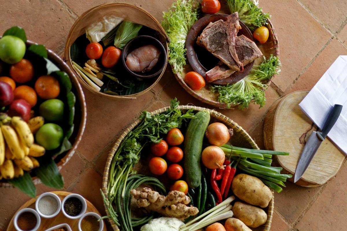a table with baskets of different types of fruits and vegetables