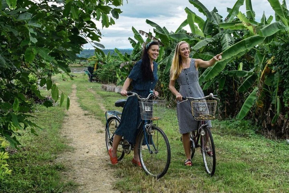dvi moterys važiuoja dviračiais purvinu taku