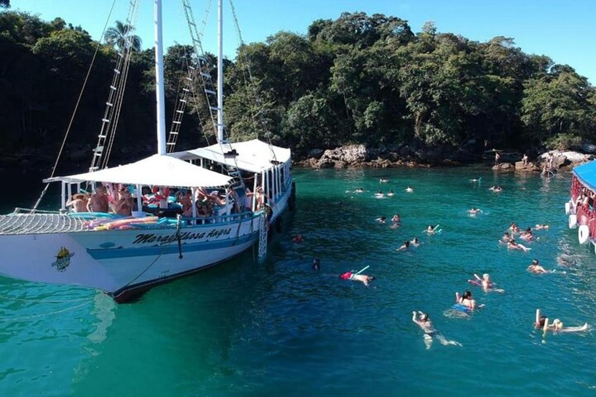 un grup de persones nedant a l'aigua al costat d'una barca