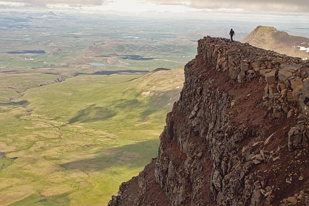 un hombre parado en el borde de una montaña