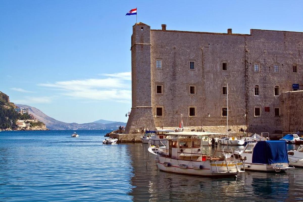 un gruppo di barche in acqua di fronte a un castello