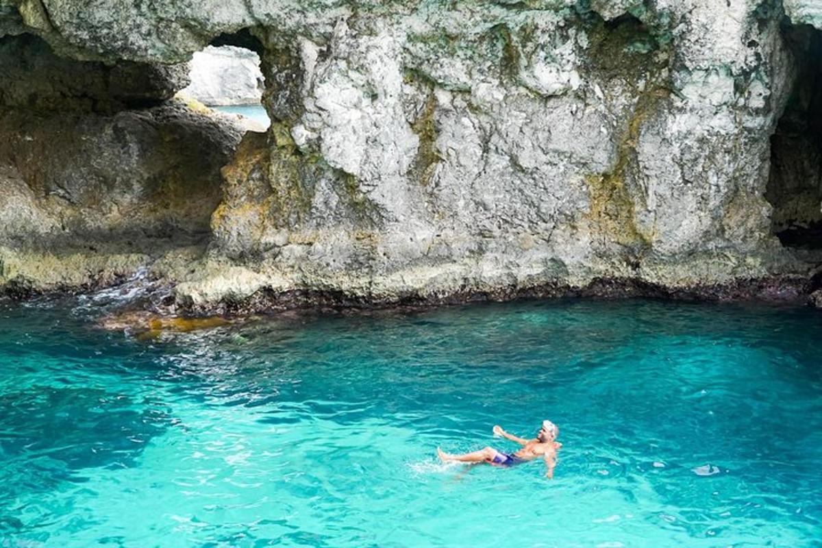 un uomo sdraiato in una pozza d'acqua accanto a una scogliera
