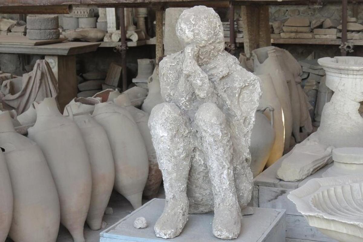 a statue of a person sitting on some vases