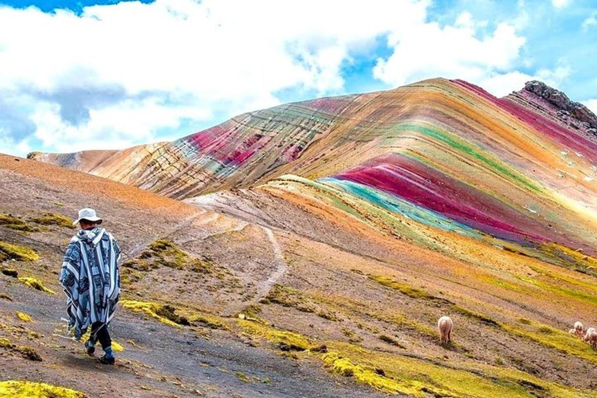 una persona che cammina davanti a una collina arcobaleno