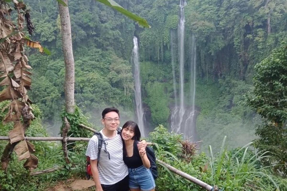 ein Mann und eine Frau stehen vor einem Wasserfall