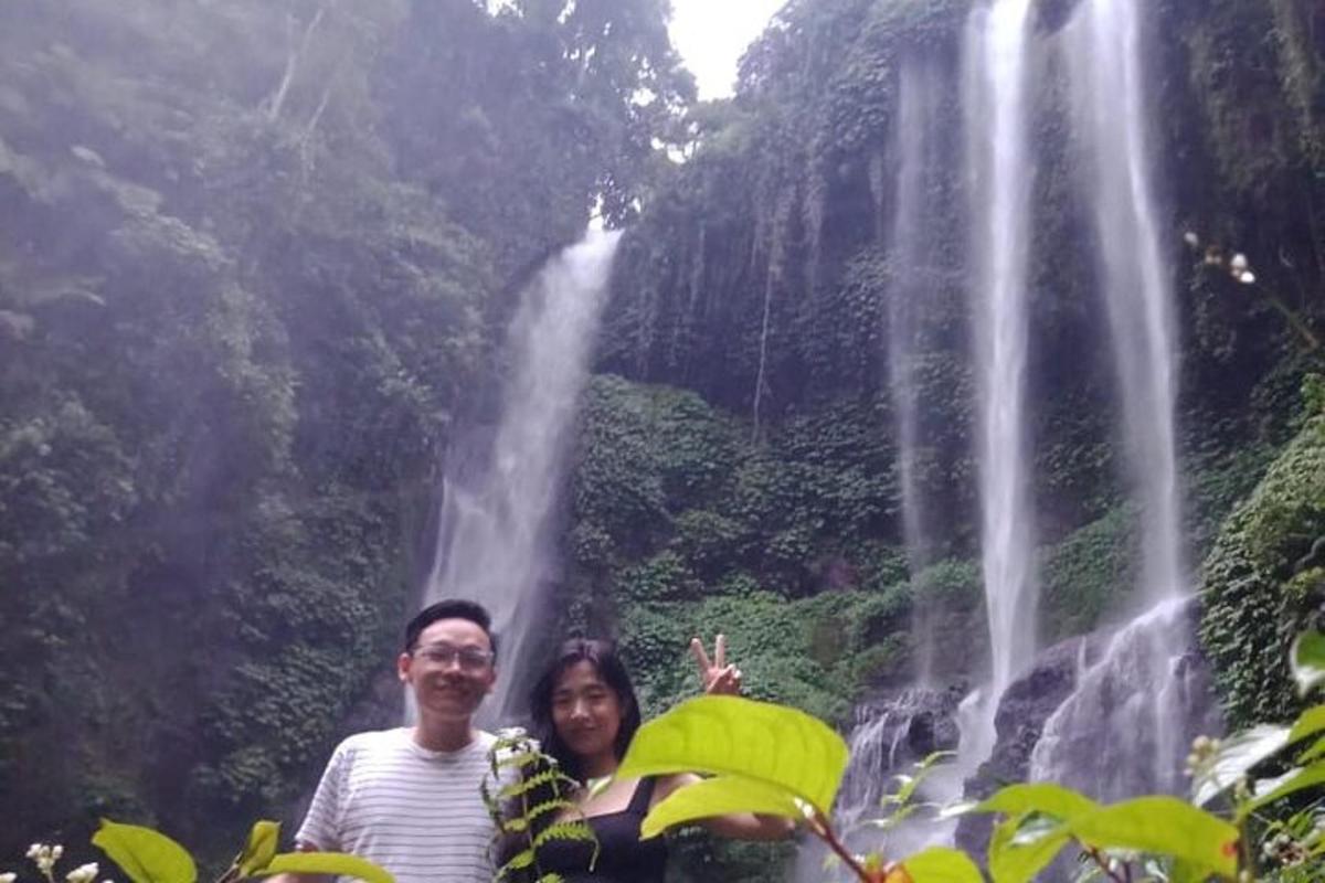 seorang lelaki dan wanita berdiri di hadapan air terjun