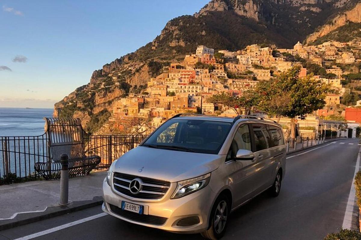 un furgone argentato parcheggiato su una strada vicino all'oceano