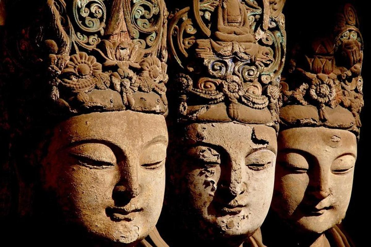 a row of statues of heads on a wall