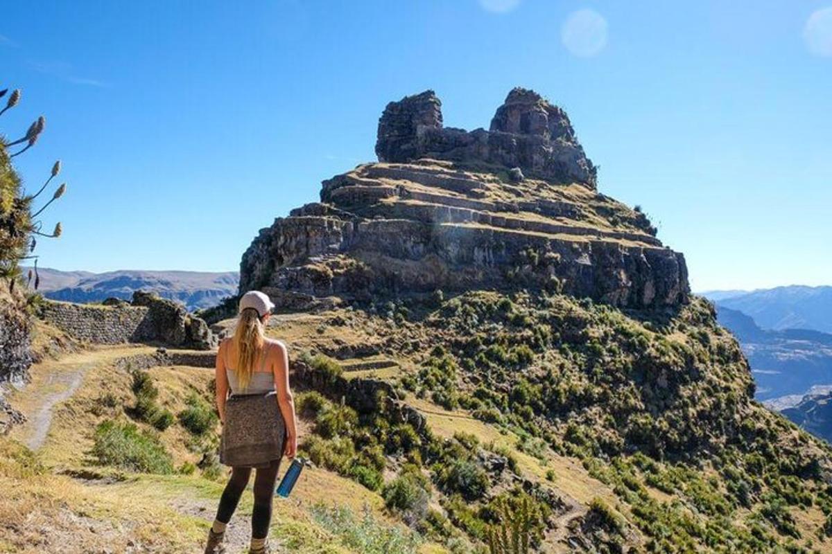 una mujer parada en la cima de una montaña
