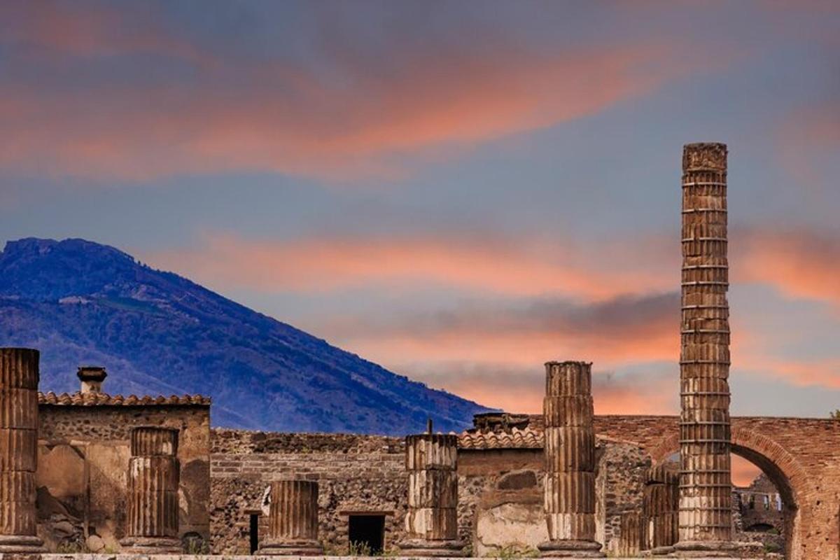 un antico edificio con colonne e una montagna sullo sfondo