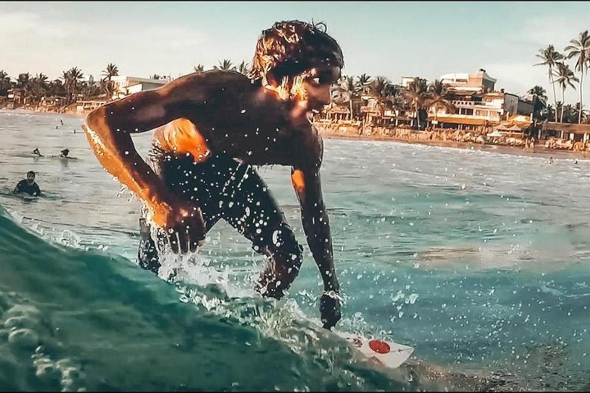 muž jedoucí na vlně na surfovém prkně v oceánu