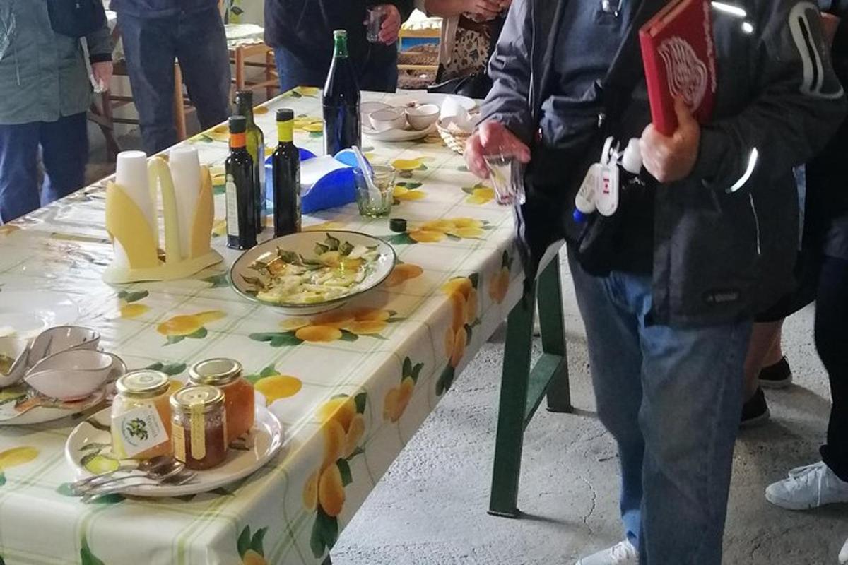 una persona in piedi accanto a un tavolo con cibo e vino