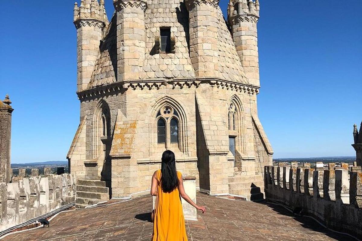 una donna in abito giallo in piedi davanti a un castello