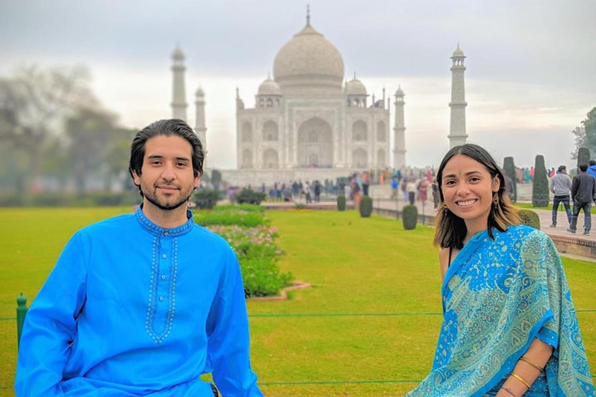 a man and a woman standing in front of the taj mahal