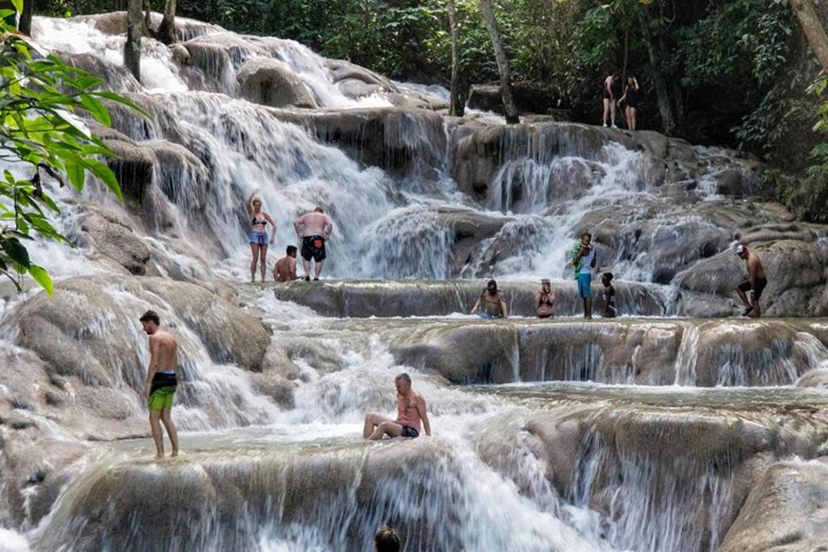 mga taong nakatayo sa tubig sa isang talon