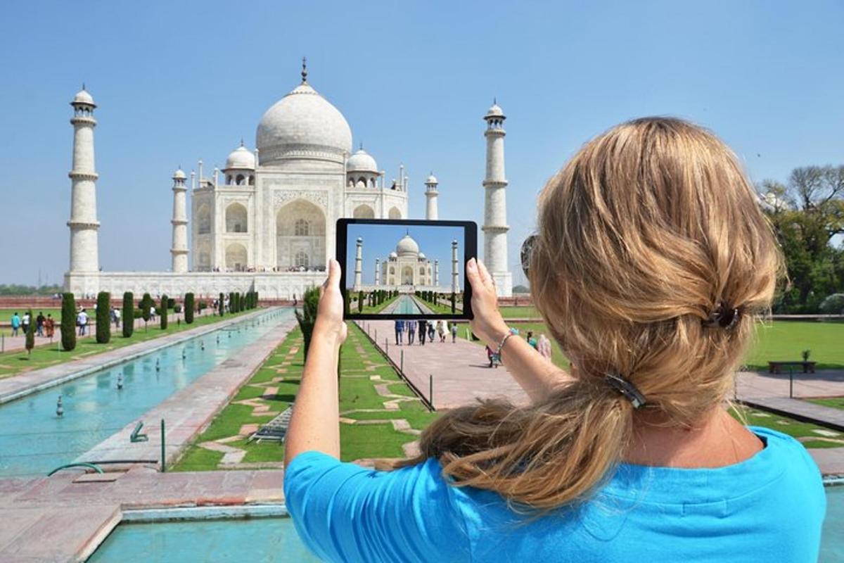 a woman taking a picture of the taj mahal