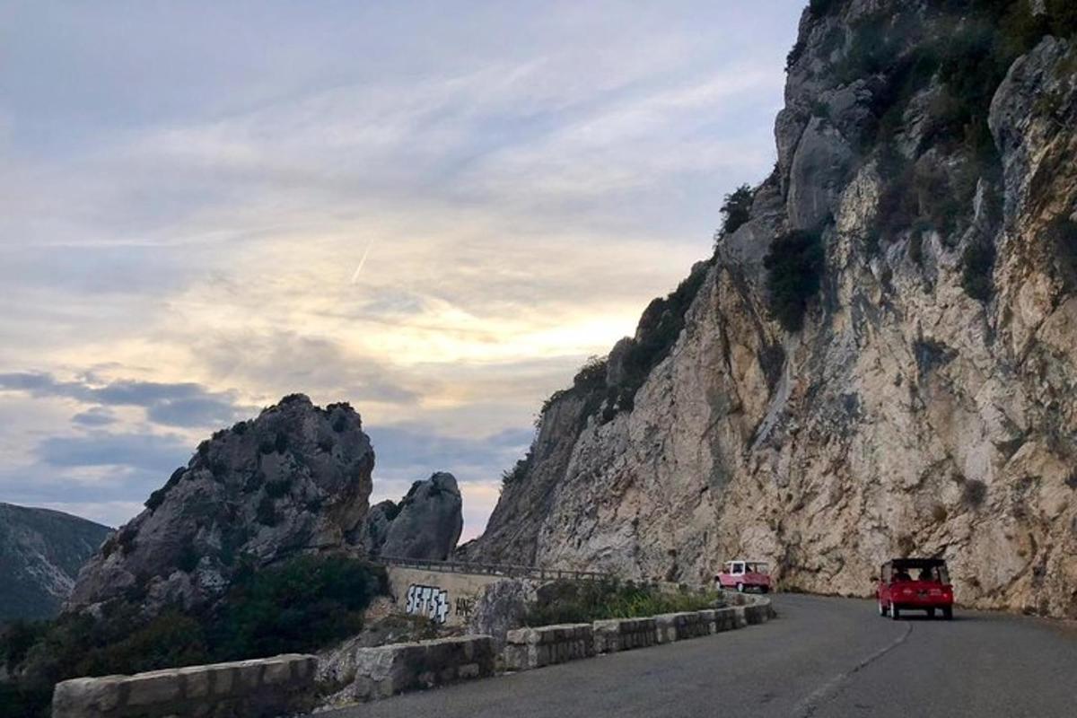 una strada di montagna con auto che circolano sulla strada
