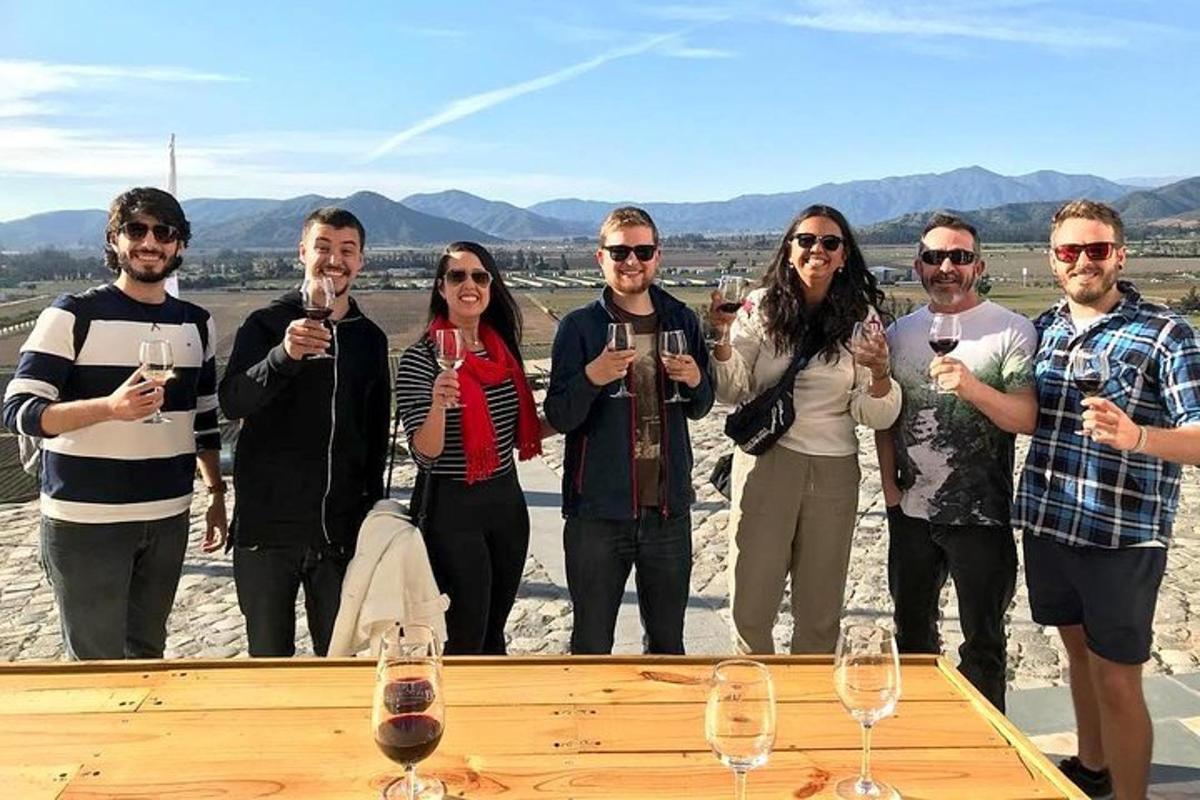 un gruppo di persone in piedi attorno a un tavolo con bicchieri di vino