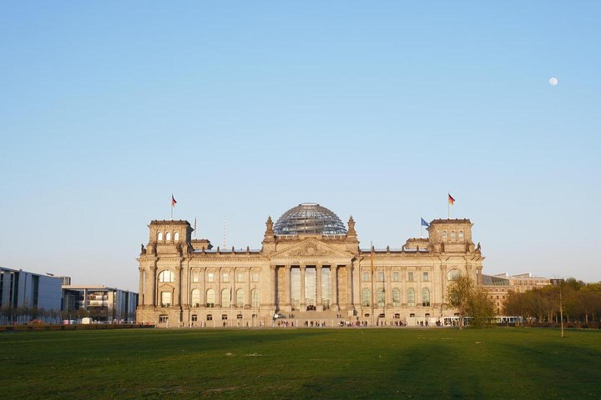 un grande edificio con un campo erboso di fronte