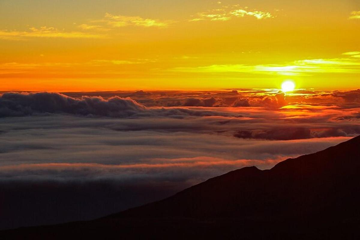 ein Blick auf die Sonne, die über einer Wolkenschicht aufgeht