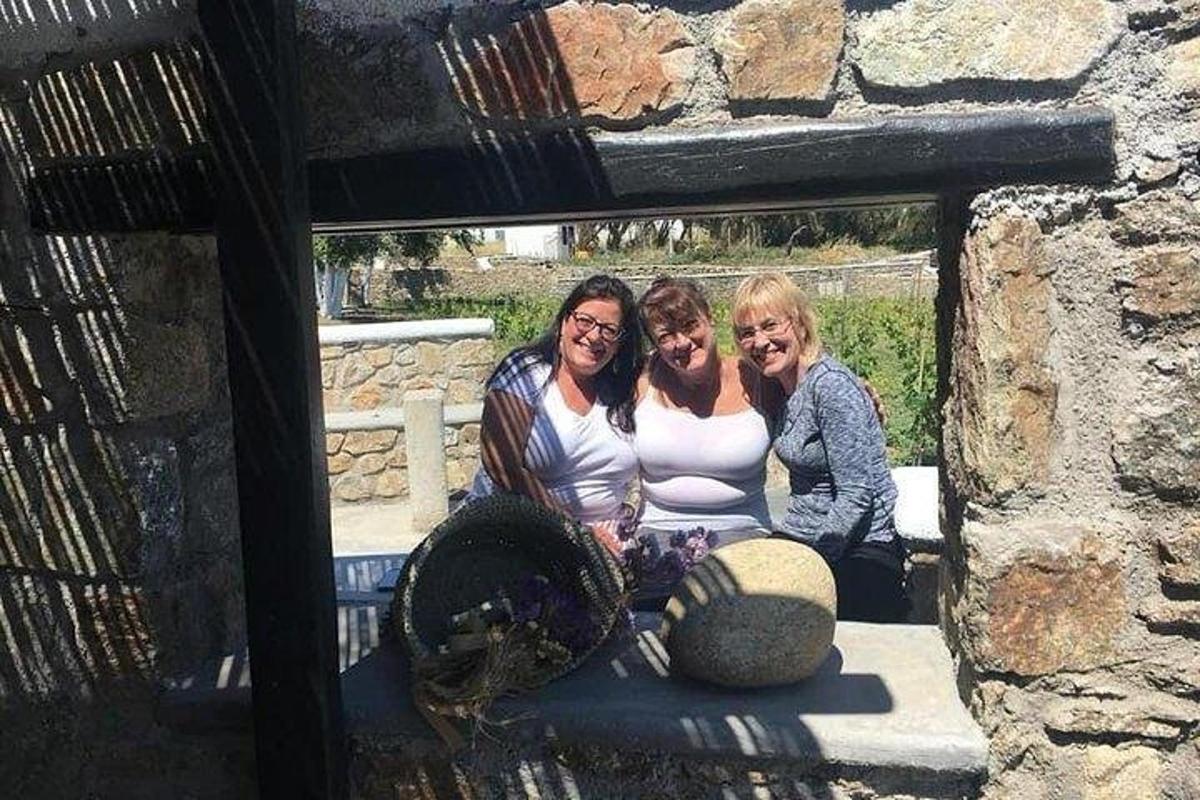Un grupo de tres mujeres sentadas en un banco de piedra