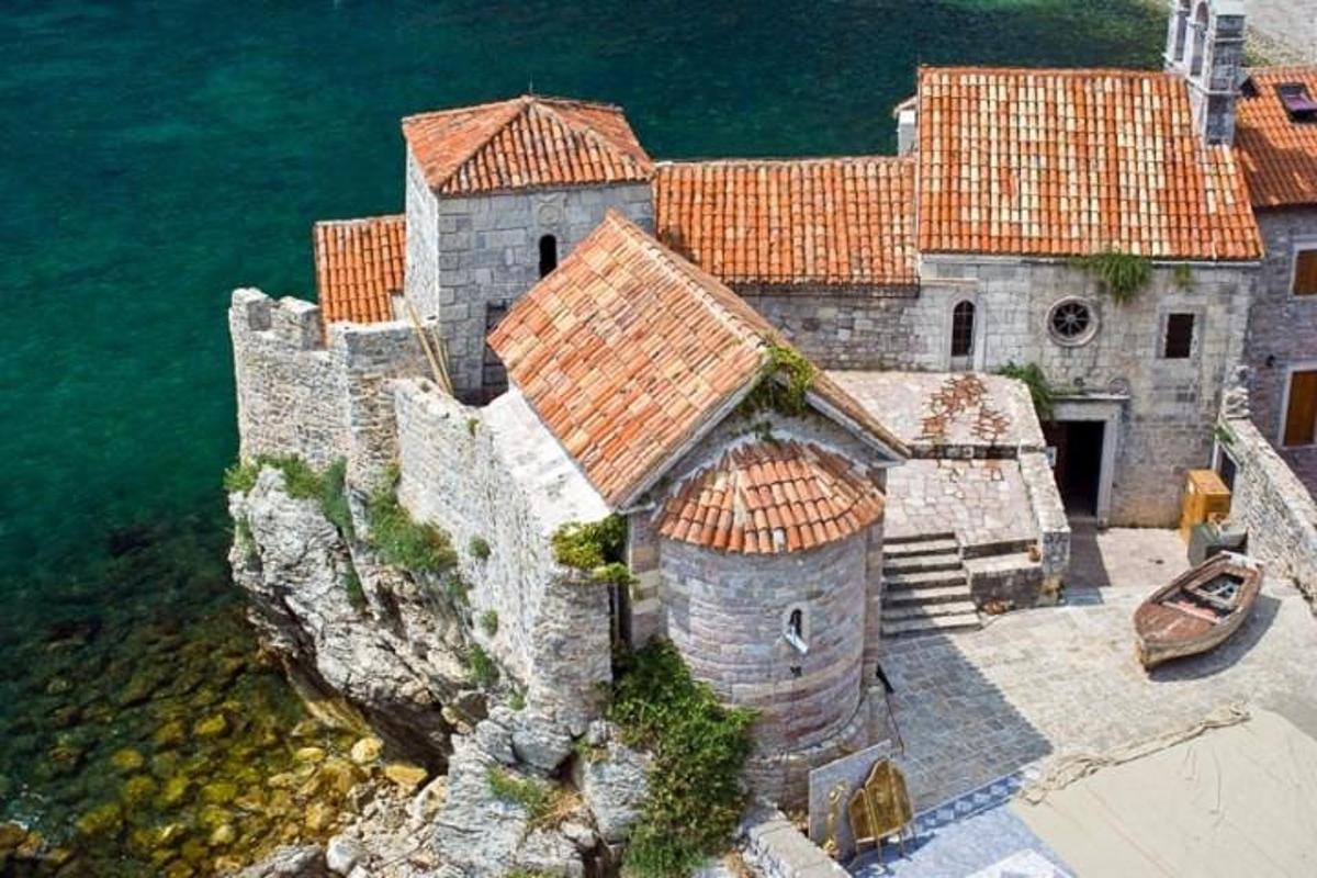 Un edificio antiguo en un acantilado junto al agua.